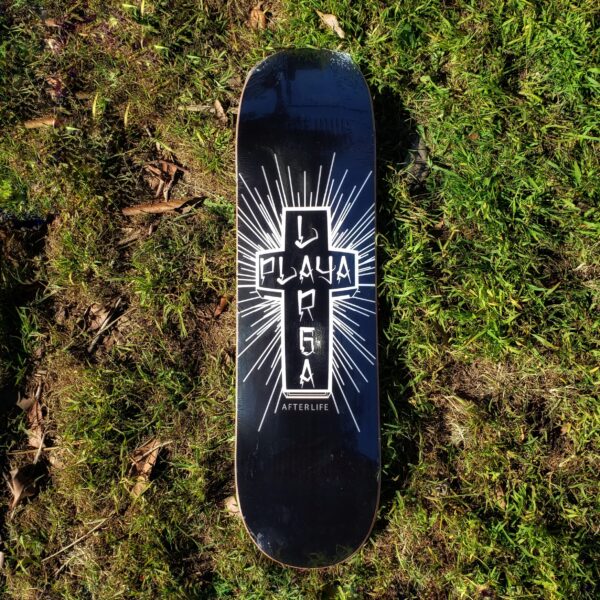 Skateboard with a black cross design and text on grass.