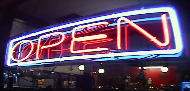 Bright neon open sign glowing at night.