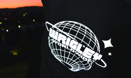 Wrigley World globe logo illuminated on dark background.